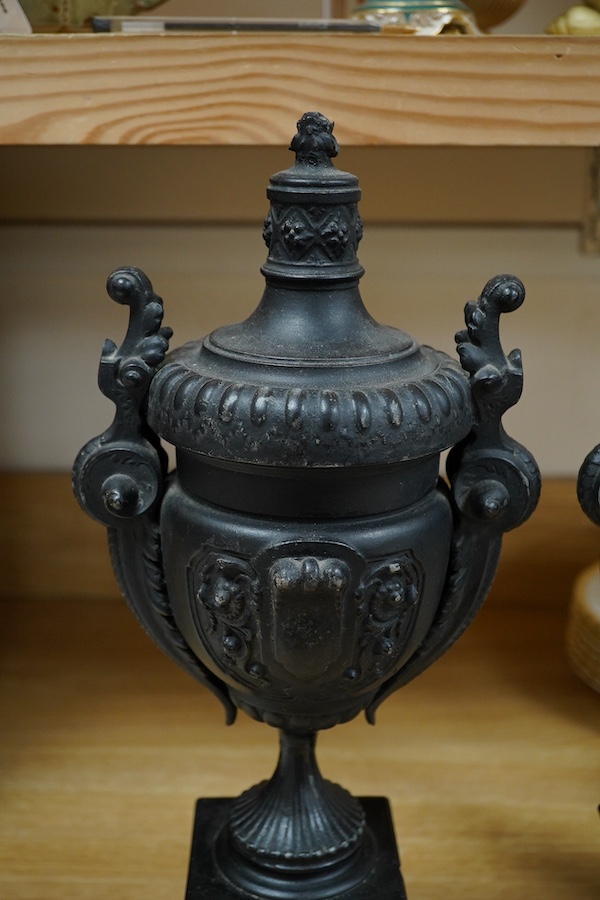 A pair of Victorian black metal and marble mantel clock garnitures, 45cm high. Condition - good